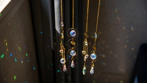 Detailed close-up of brass suncatchers featuring crystal prisms and celestial symbols