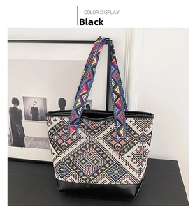 Close-up of geometric woven tote bag featuring colorful patterns and black leather accents