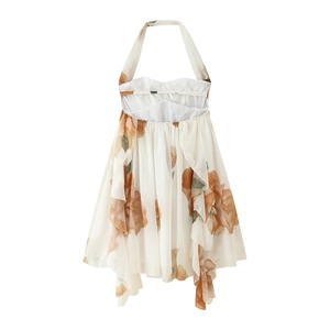Detail of white halter neck dress featuring orange floral print and ruffled hemline