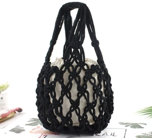 Detail of black hand-woven mesh tote bag with beige drawstring inner pouch on white background