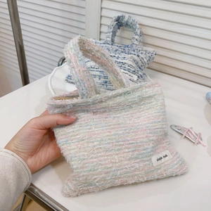 Dettaglio della borsa a mano in tweed colorato con cerniera in metallo e etichetta ricamata