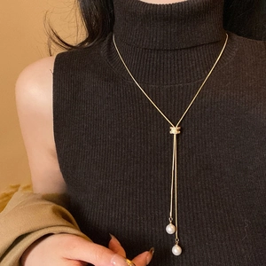 Collier minimaliste en Y doré avec fermoir zircon et perles sur pull noir