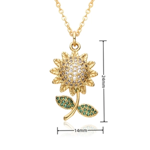Macro shot of gold sunflower pendant with white zircon center and green leaf stones