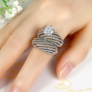 Detailweergave van een luxe meerlaagse zilveren ring met grote zirkoon aan de hand