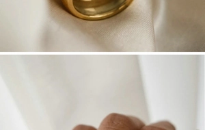 Detail view of gold 18K plated double-layer titanium steel ring on hand and fabric
