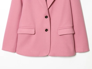 Dettaglio del blazer rosa effetto lana con cuciture e tasca a pattina rifinita