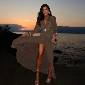 Détail d'une robe col en V profond avec boucle métallique et fente haute au coucher du soleil