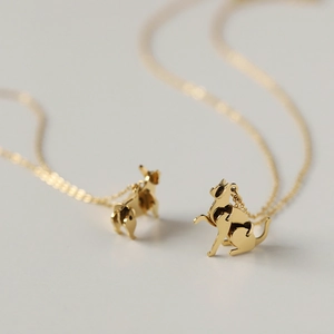 Macro shot of 3D gold-plated cat pendant with high-polished surface on a delicate O-chain
