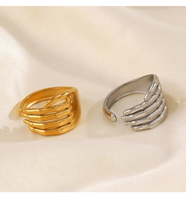 Detailed view of adjustable gold and silver hugging hand rings on white satin fabric