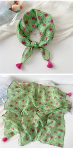 Detail view of light green floral cotton linen scarf with pink tassels and breathable fabric