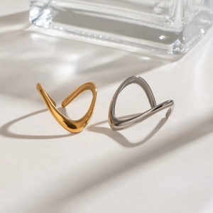 Detailed view of wave-shaped stainless steel rings in polished gold and silver finishes