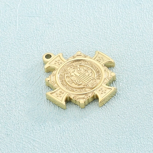 Close-up of golden exorcist cross pendant with intricate religious relief details