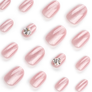 Pink cat eye press-on nails with silver glitter and rhinestone pearl accents on white