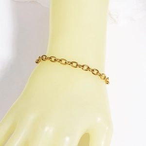 Dettaglio del bracciale a catena in titanio placcato oro 18K su un modello di polso