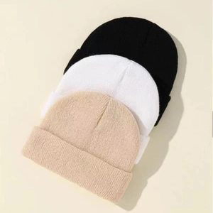 Detail view of premium knitted beanies in black white and beige showing ribbed texture