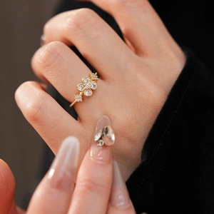 Close-up of gold flower ring with micro-pave cubic zirconia on a female finger