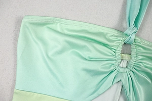 Detail of ruched fabric with ring accent and gradient mint green tie-dye texture