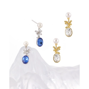 Silver and gold pineapple earrings with pearls and water-drop gems on glass props