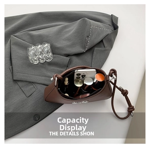 Detail view of the spacious interior of this dark brown leather bow shoulder bag