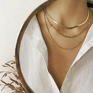 Detailed mirror shot of layered 18K gold plated Figaro and flat snake chain necklaces