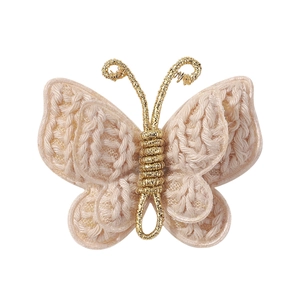 Macro detail of handmade crochet butterfly hair clip with golden metallic wire core