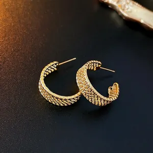 Irregular multilayer C-shaped gold metal earrings with a woven texture finish