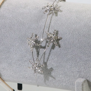 Silver star headband with sparkling rhinestones displayed on a gray jewelry holder
