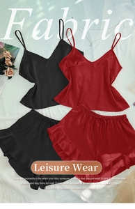 Flat lay of satin pajama sets in black and red with delicate camisole and ruffled shorts