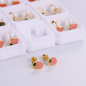 Detail of strawberry stud earrings with pink enamel and gold finish in gift box