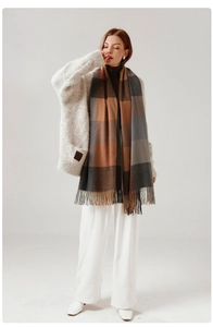 Detail view of the soft fringed hem and textured plaid pattern on this oversized scarf