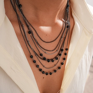 Detail of multi-layered black glass beaded necklace with snake chains for women