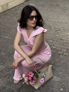 Detail of pink knitted V-neck top with ruffle sleeves and matching ribbed midi skirt