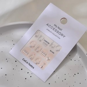 Detailed macro view of MJ-056 3D nail art charms with silver accents and small pearls