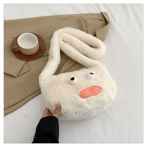 Detail of cute cream plush crossbody bag with cartoon eyes and orange sausage mouth design