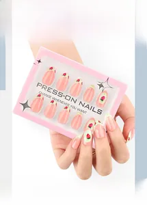 Detail of pink almond press-on nails featuring strawberry designs and green lace accents