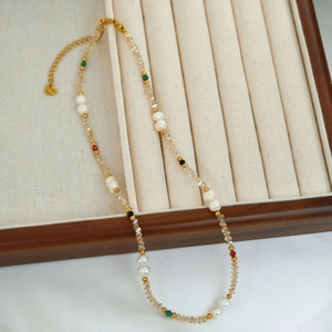 Detailed shot of pearl and crystal beaded necklace on cream velvet jewelry tray