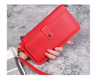 Detail of red leather long wallet with zipper, wrist strap and magnetic buckle pocket