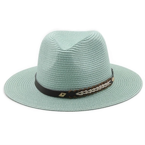 Detailed weave texture of a mint green straw fedora hat with a black leather band and gold buckle