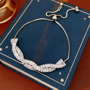 Gros plan d'un bracelet en argent torsadé ajustable avec zircone sur un livre bleu