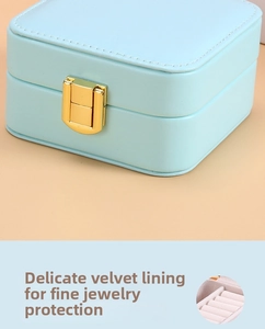 Detail of light blue faux leather jewelry box featuring gold metal clasp and stitching