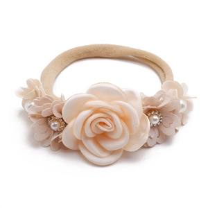 Close-up of baby headband with champagne fabric roses and imitation pearl accents