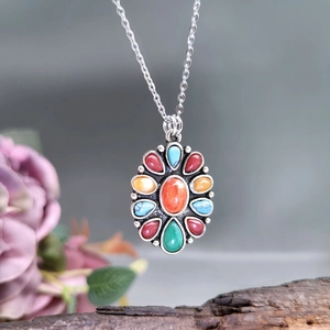 Macro detail of vintage silver pendant with colorful gemstone inlay and oval pattern