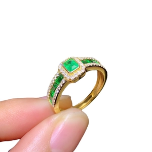 Luxury emerald-cut green gemstone ring with sparkling diamonds in a gold setting