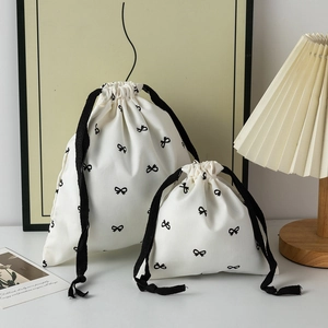 Cream cotton drawstring storage bags with black bow print and matching cotton rope