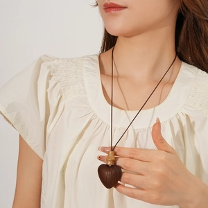 Close-up of heart wood pendant necklace on model with ethnic bamboo style design