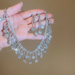 Detail of silver flower necklace and fringe earrings set with sparkling zircon crystals