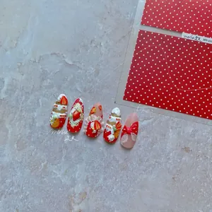 Detailed view of handmade press-on nails featuring 3D cream flowers and strawberry charms