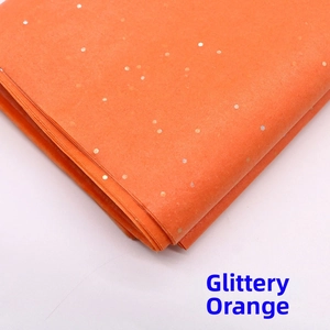 Macro shot of sparkling orange flower wrapping tissue paper with silver laser sequins