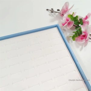 Detail view of 100-slot jewelry display tray with blue frame and soft white ring inserts