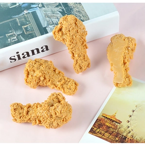 Dettaglio di quattro modelli di pollo fritto in PVC con texture dorata realistica